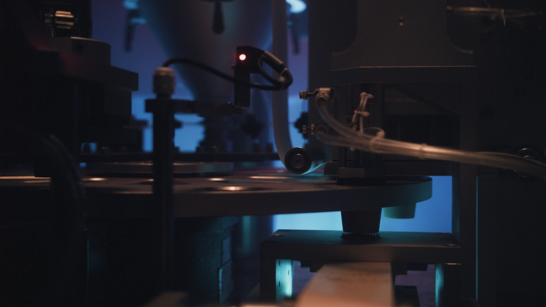 Darkly lit industrial machine with a focus on mechanical components and coffee pods.